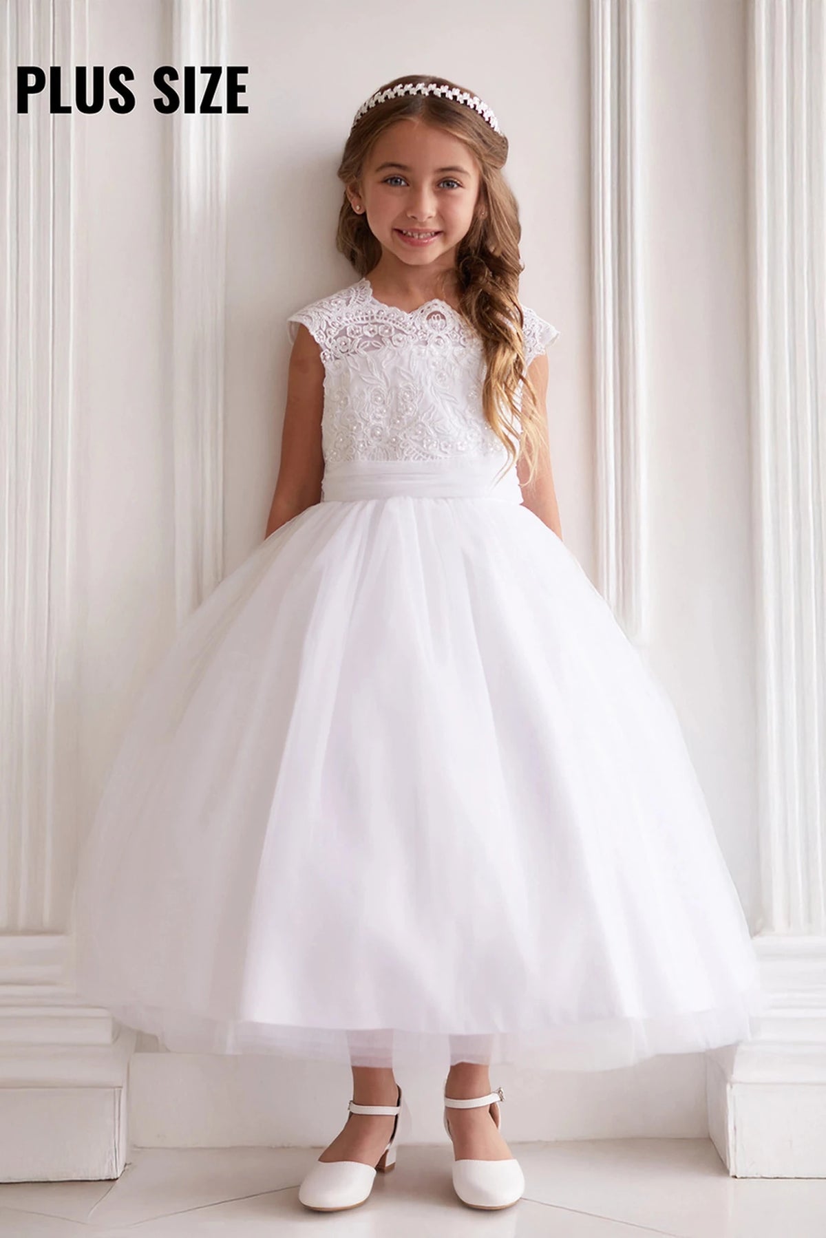 Emphasis on a scalloped lace neckline of the white flower girl dress.