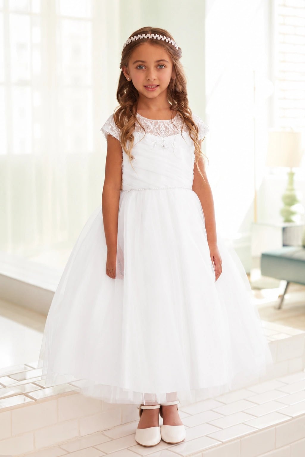 Tiny beads make a slim belt on the off-white flower girl dress.