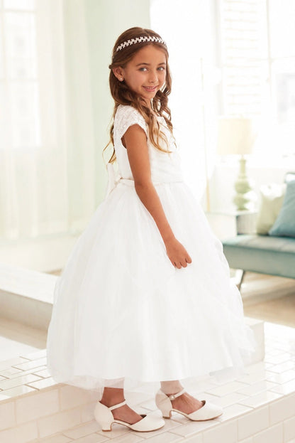 Airy tulle fans from the waist of this off-white flower girl dress.