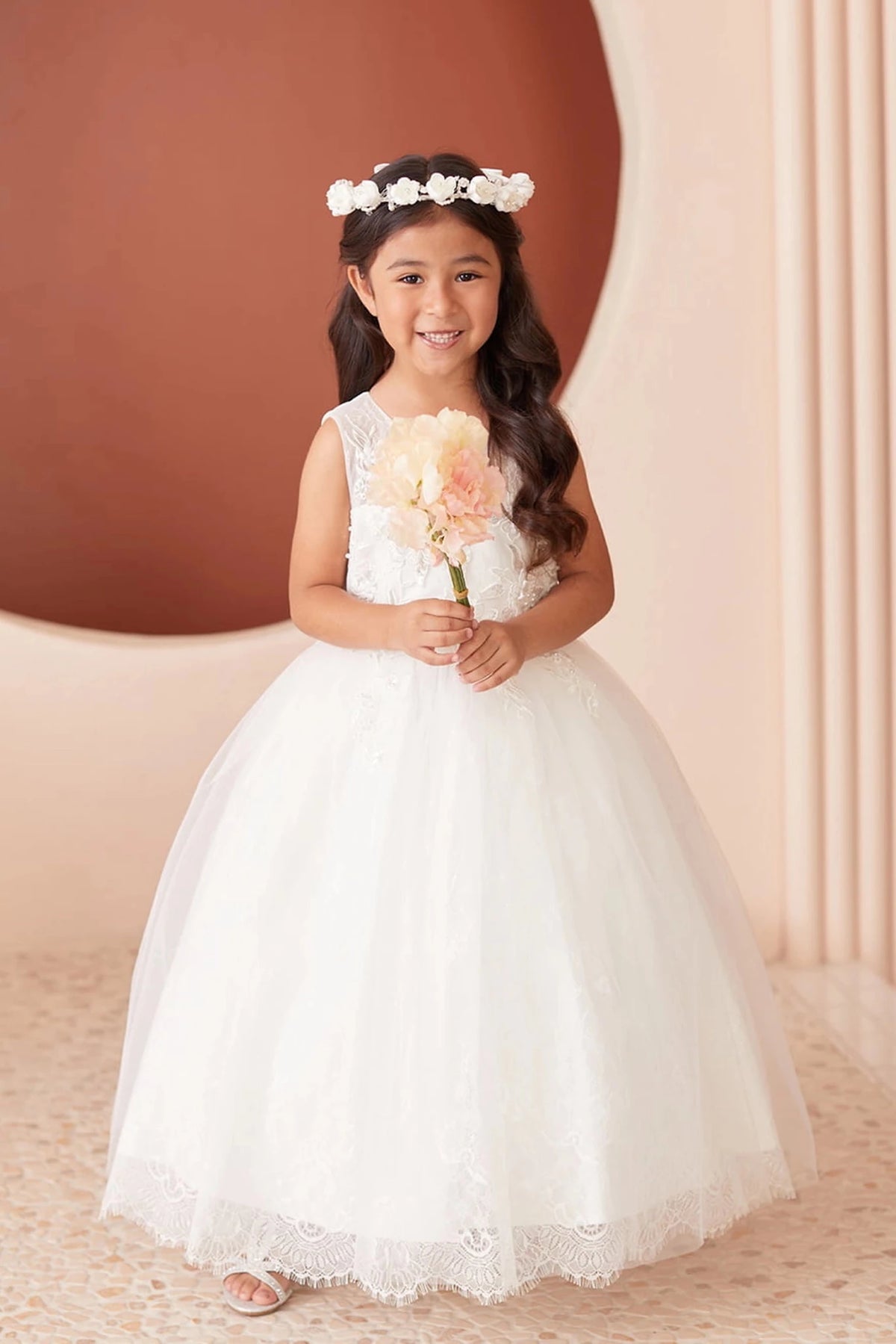 Scalloped lace finishes the off-white flower girl dress's broad skirt hem.