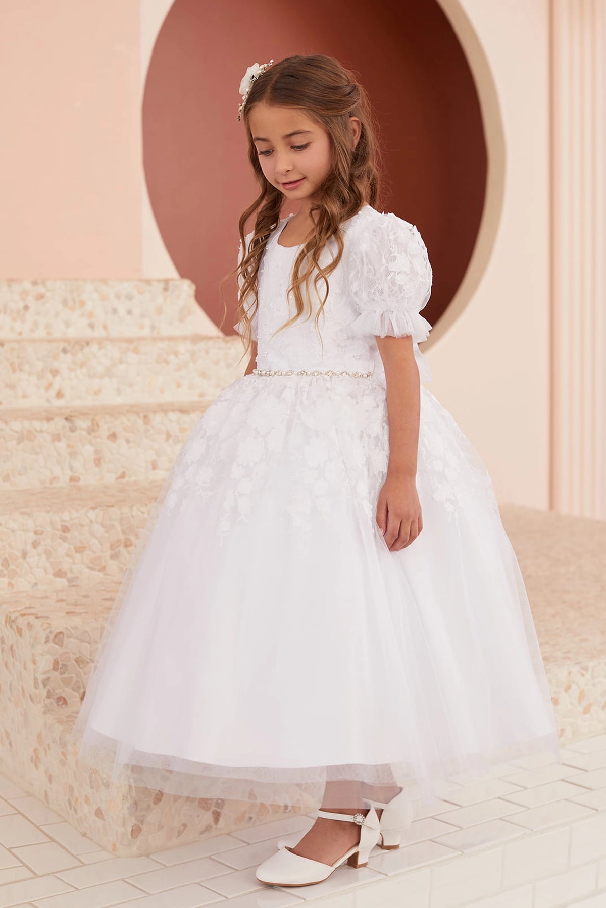 Lace-trimmed hem accents the white flower girl dress.