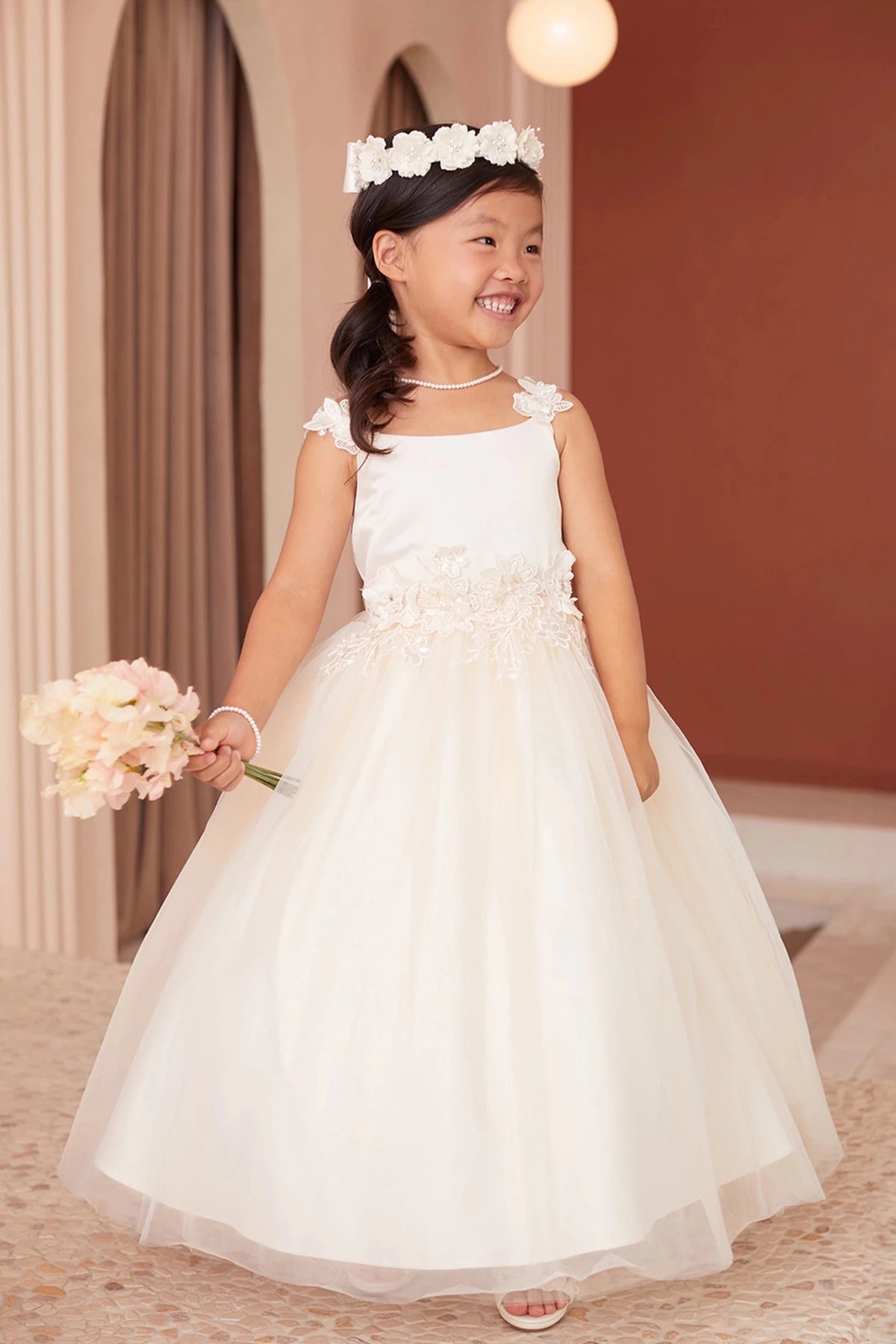 Champagne flower girl dress, showing floral shoulder straps.