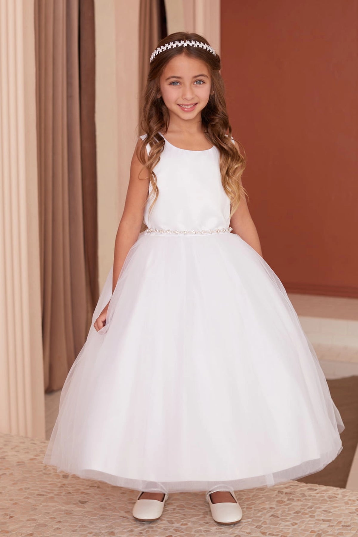 Beaded waistband accents the white flower girl dress.