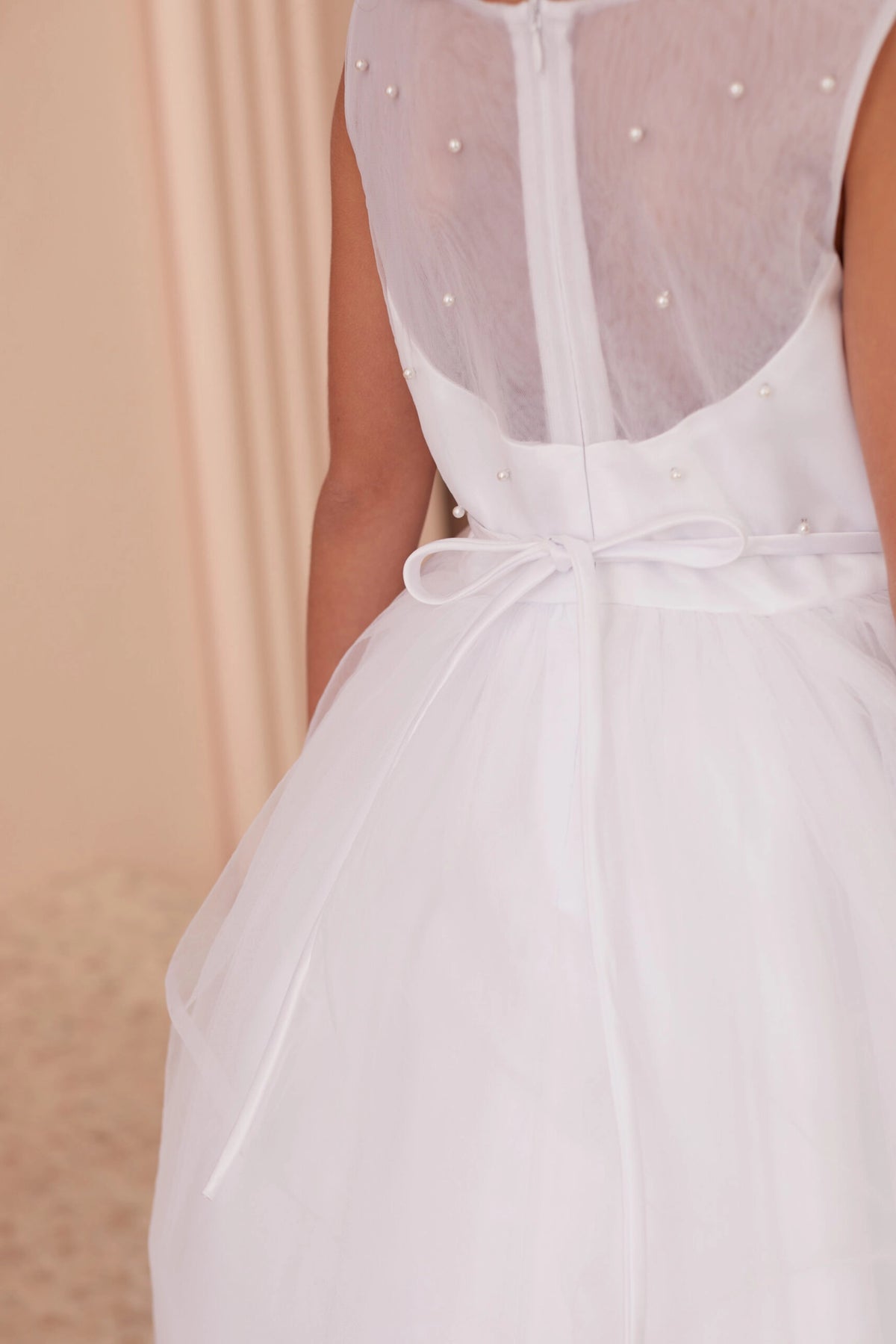 Featuring a small satin back bow, a white flower girl dress.