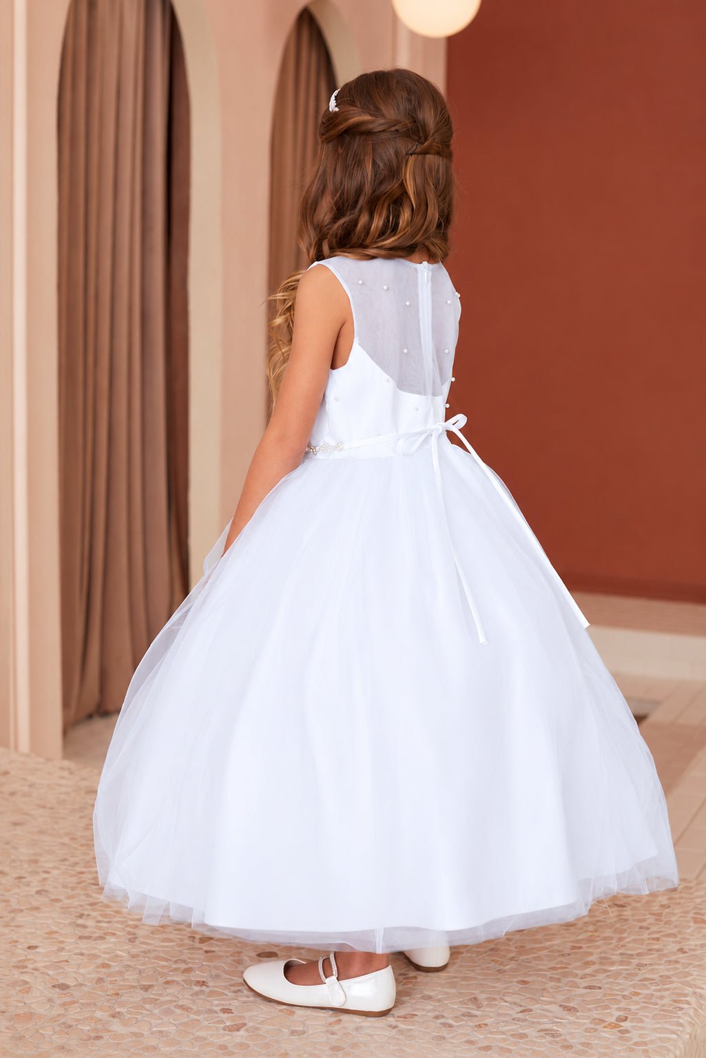 Three-quarter back view of Tiptop 5863 white flower girl dress showing the pearl-dotted sheer back and slim satin bow.