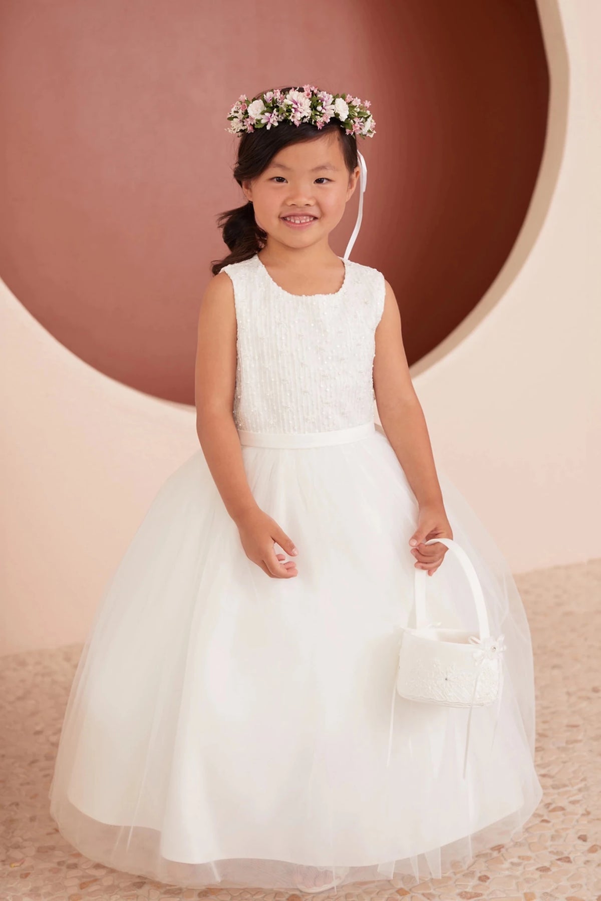 Fine rows of texture cover the off-white flower girl dress's bodice.