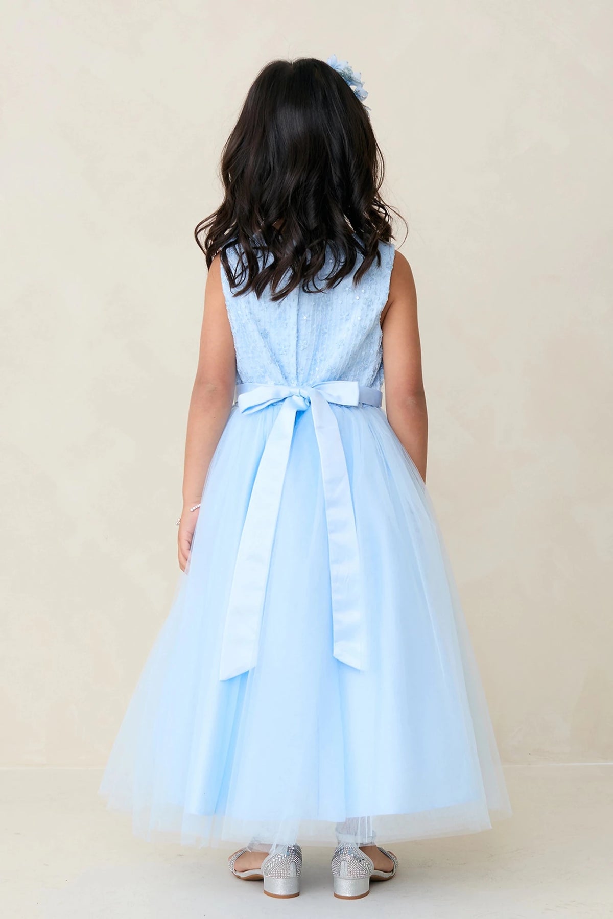 Emphasis on a long satin back sash of the sky blue flower girl dress.