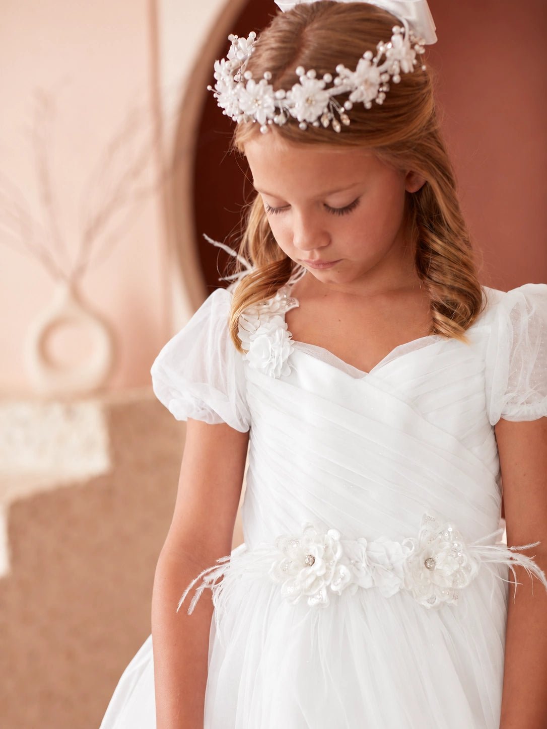 Emphasis on diagonal crossover pleats of the off-white flower girl dress.