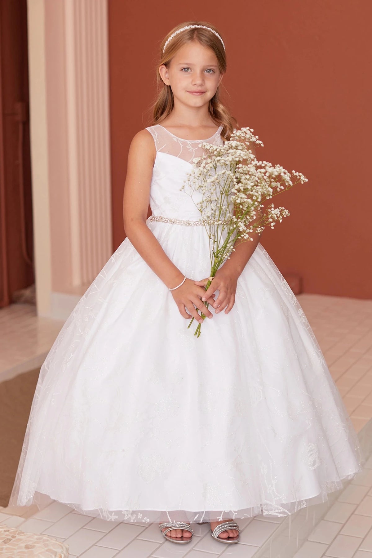 Leaf-edged tulle frames the off-white flower girl dress's skirt hem.