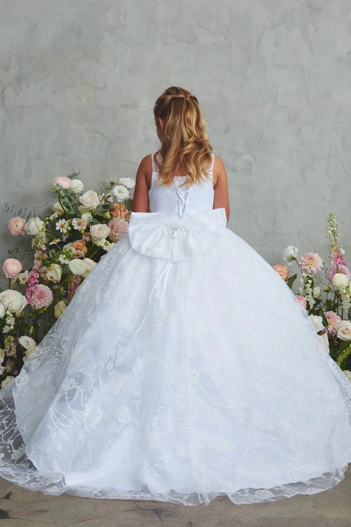 Emphasis on a long back train of the white flower girl dress.