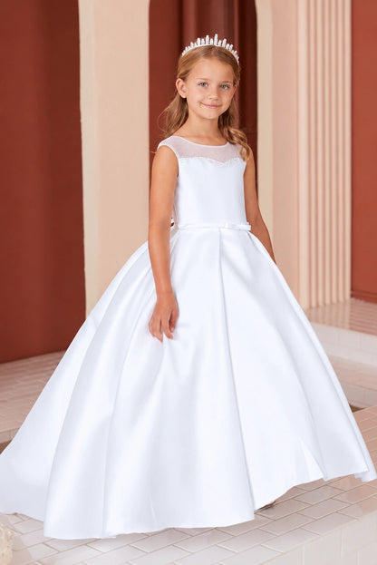 Pleats open into the white flower girl dress's full, smooth skirt.