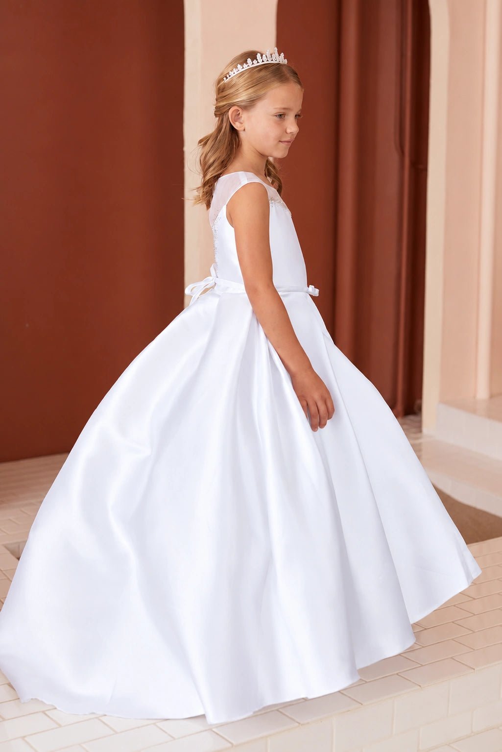 At the side, white flower girl dress panels flare outward from the waist.
