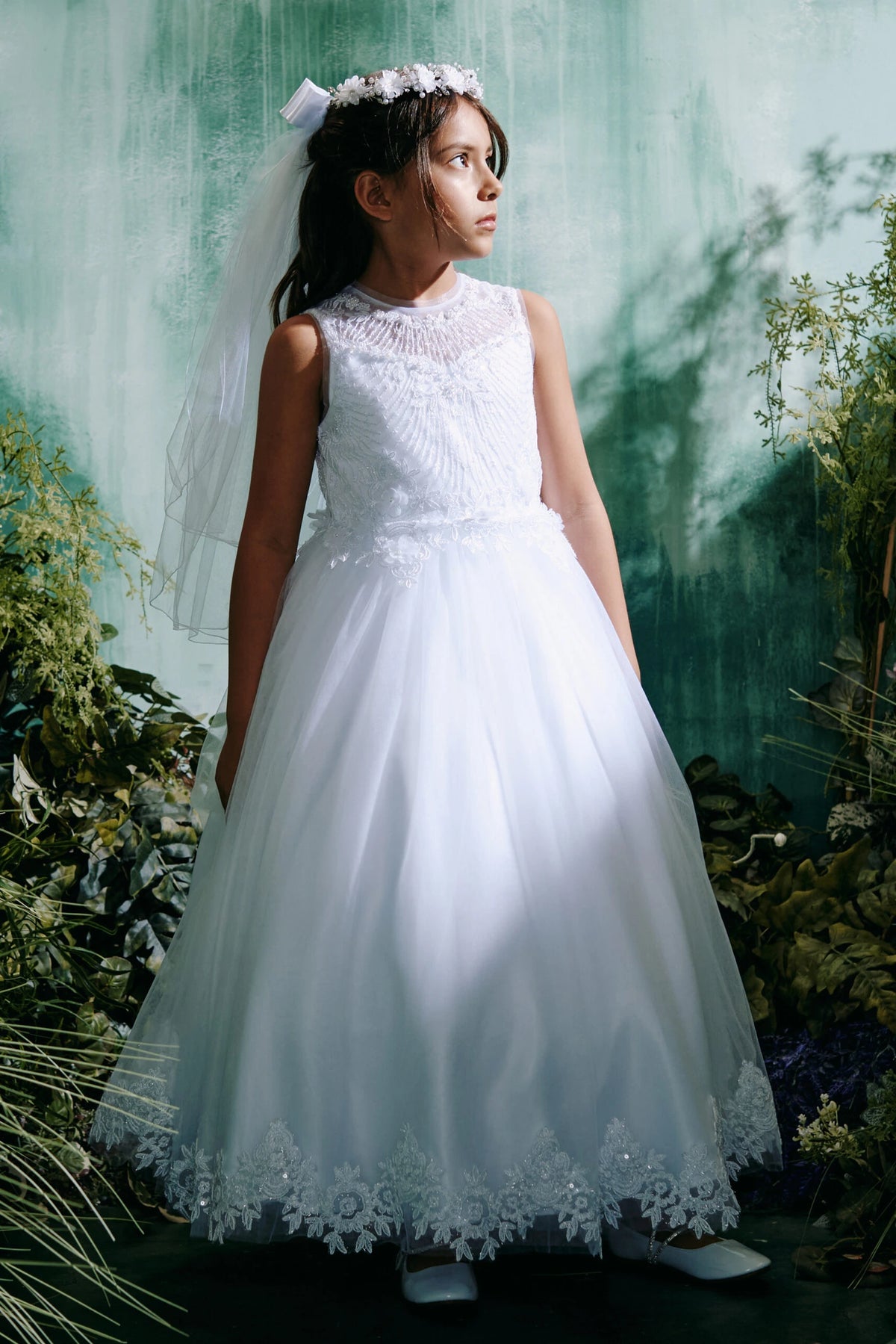 Highlighting floral skirt edging on a white flower girl dress.