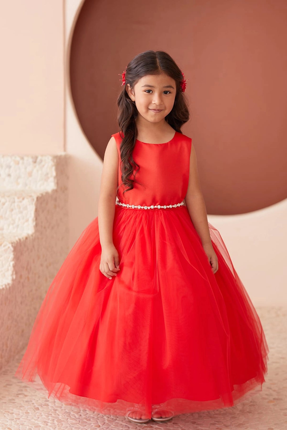 Red kids pageant dress featuring a pearl-accented waist and tulle skirt.