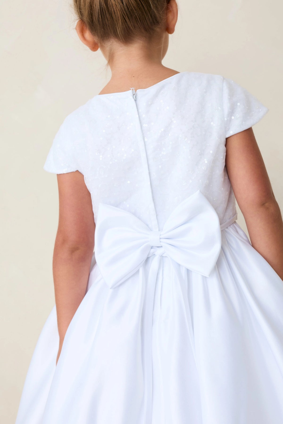 Shown here, a white flower girl dress with a satin back bow.