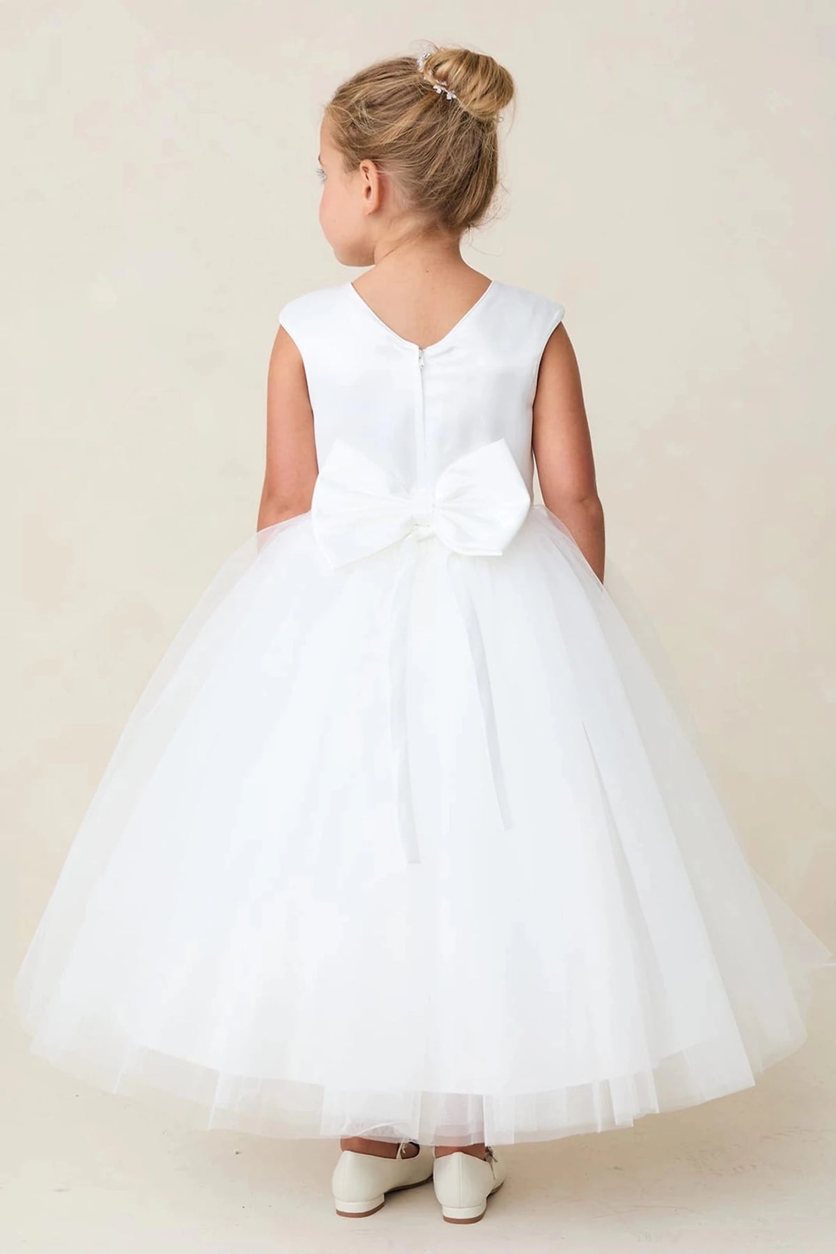 Below a V neckline, the off-white flower girl dress has a smooth satin back.