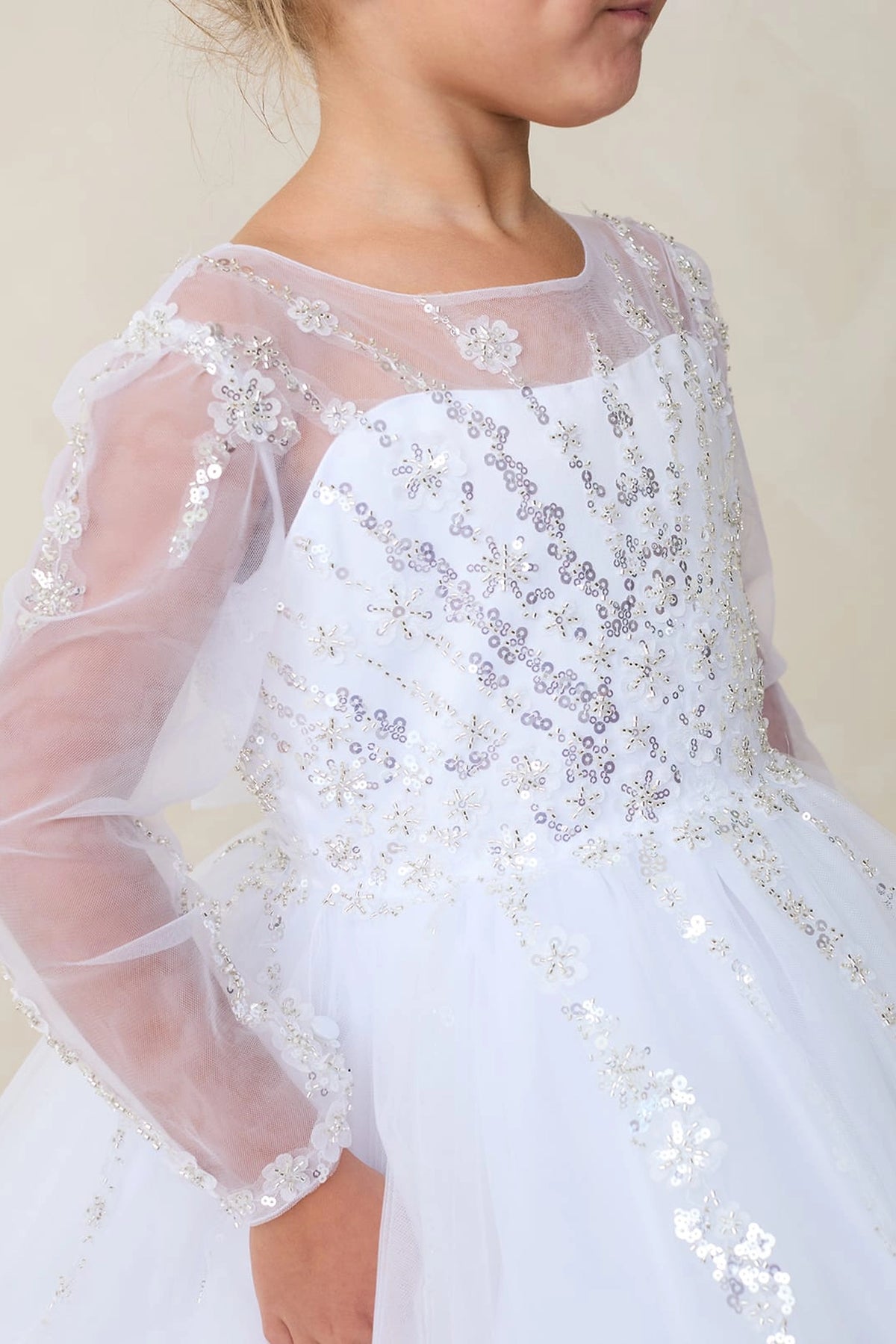 The white flower girl dress features small embroidered shoulder flowers.