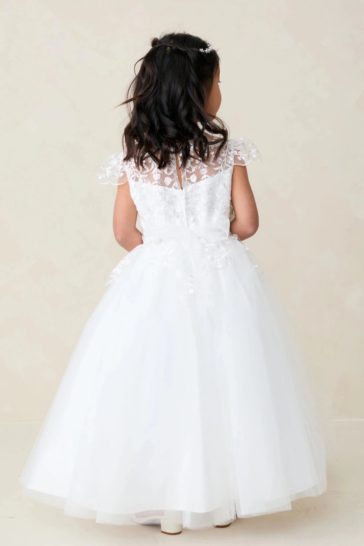 Sheer lace back is visible on the off-white flower girl dress.