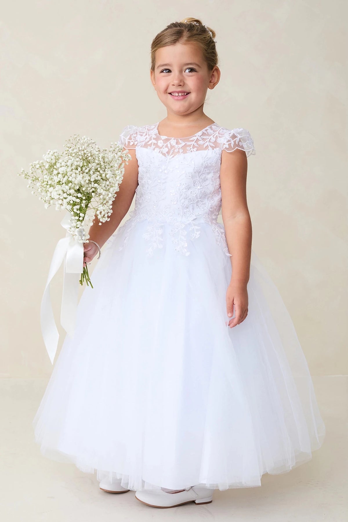 A view of floral cap sleeves on the white flower girl dress.