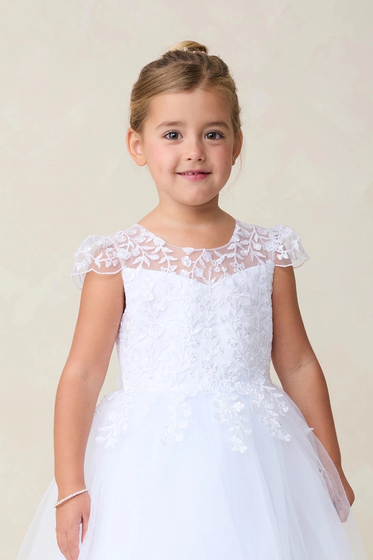 This white flower girl dress displays a lace-trimmed neckline.