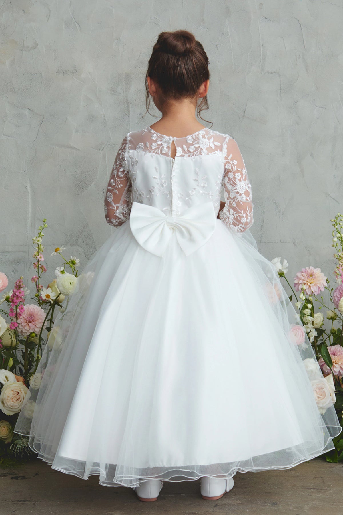 Detailed with an oversized satin bow, this white flower girl dress.
