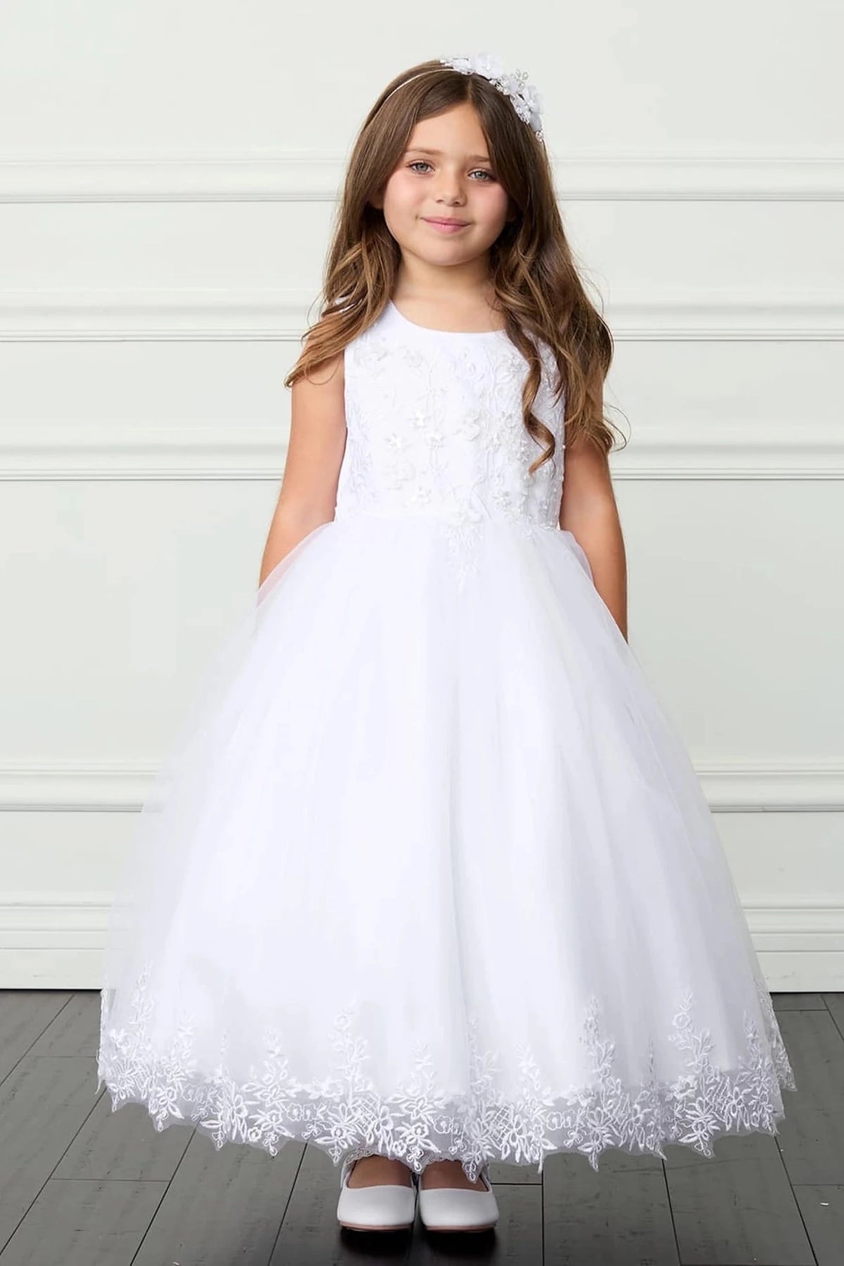 Focus on a lace-trimmed skirt hem of the white flower girl dress.
