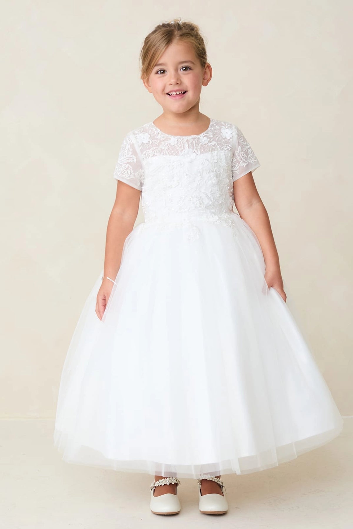 Focus on a lace-covered bodice of the off-white flower girl dress.
