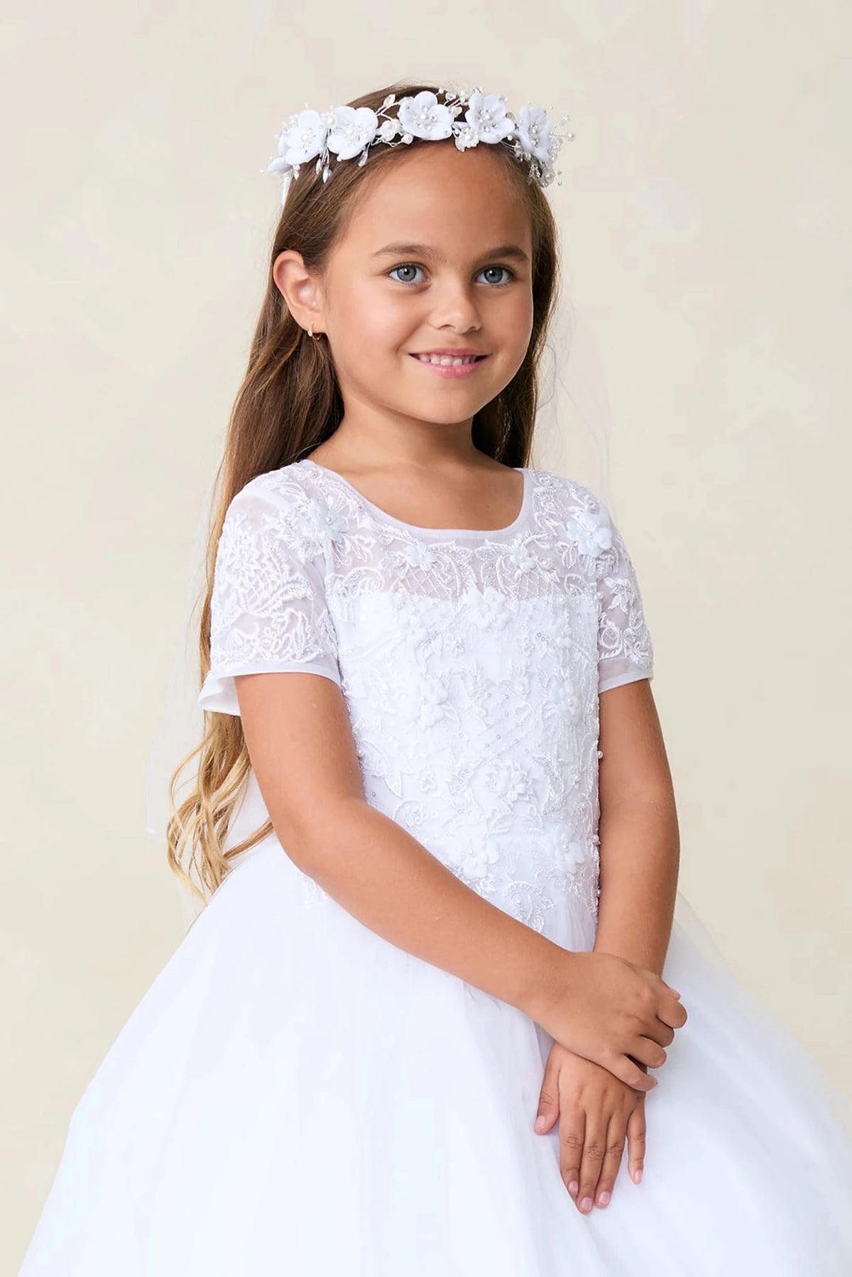 A view of a sheer floral neckline on the white flower girl dress.