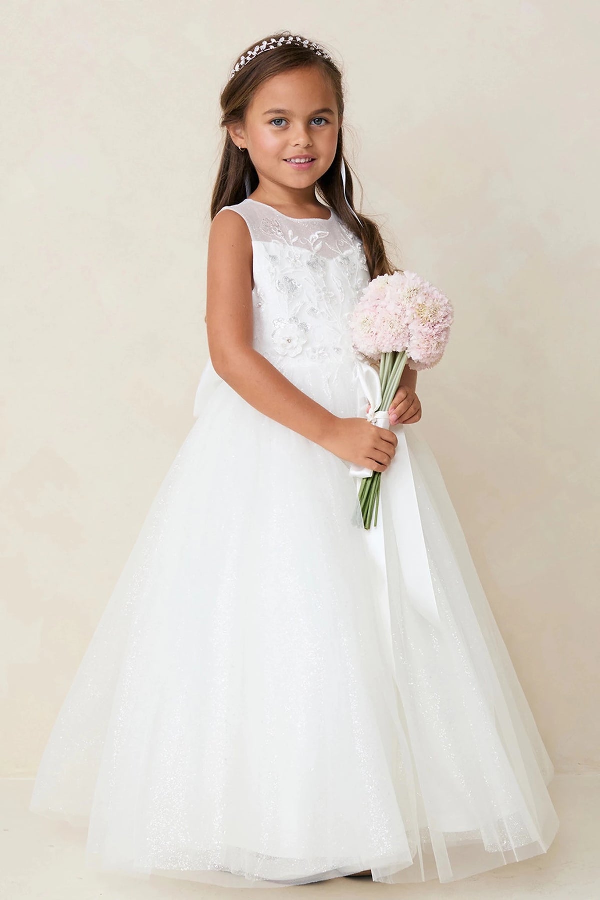 This off-white flower girl dress displays a 3D floral bodice.