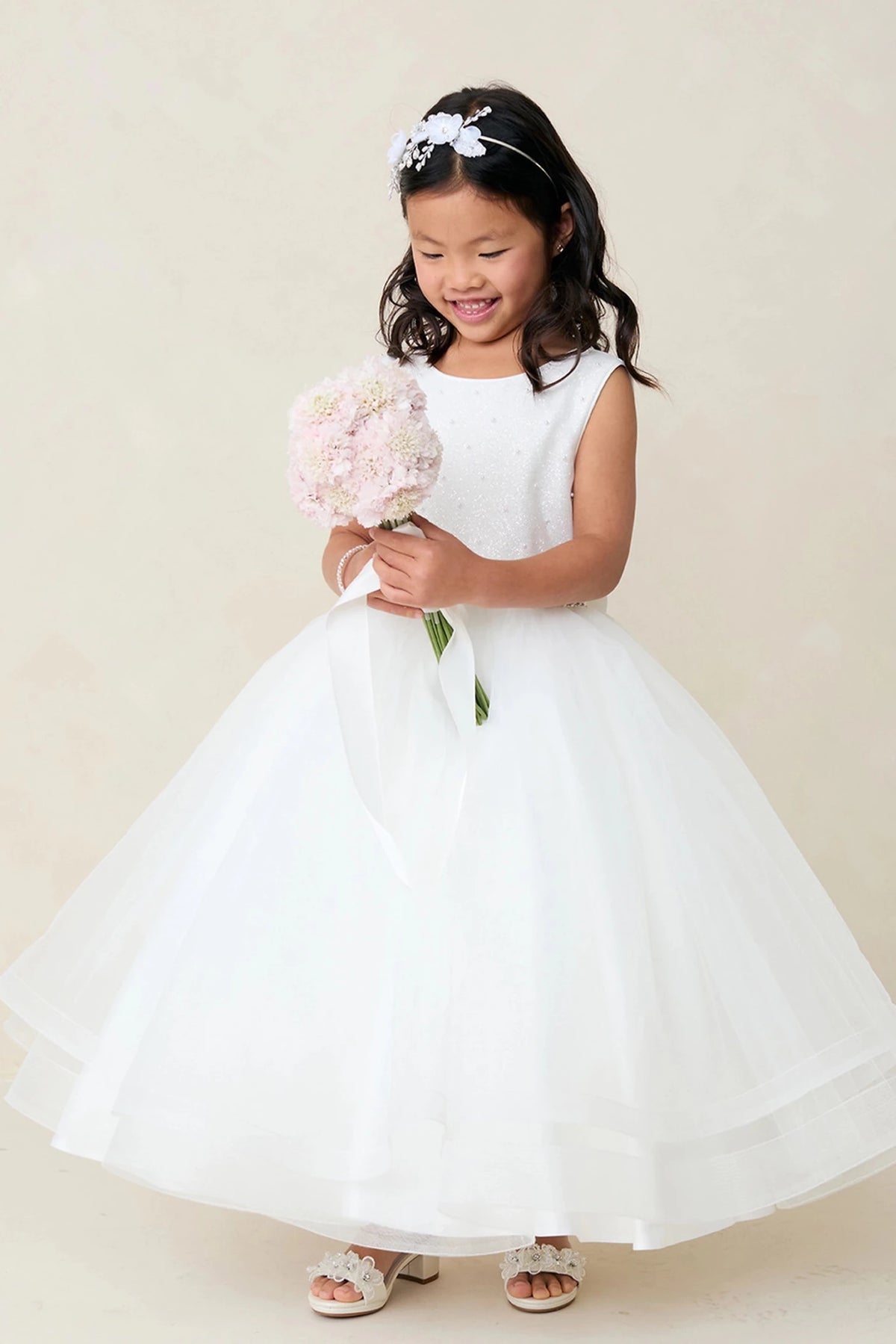Focus on a smooth satin bodice of the off-white flower girl dress.