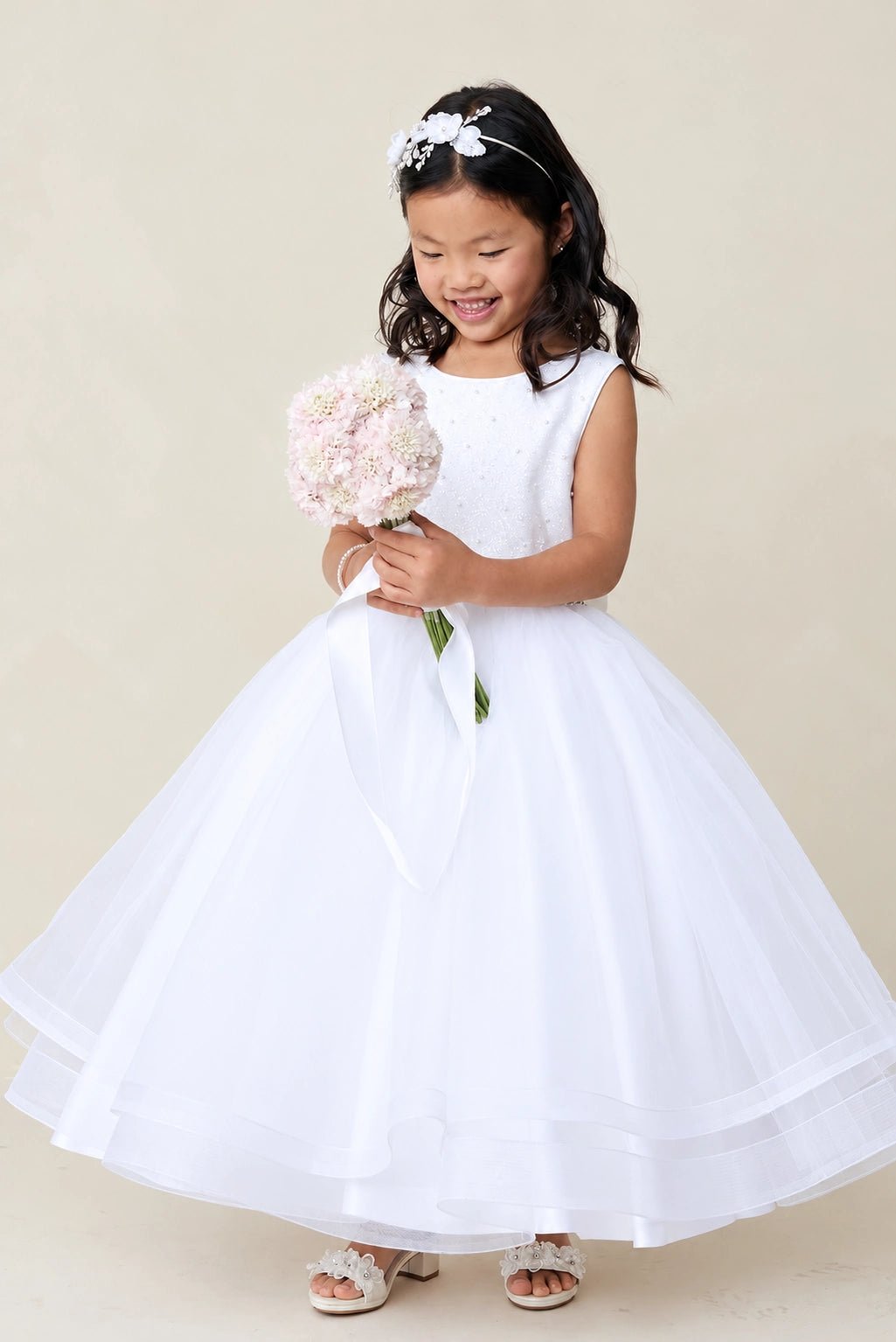 Shown here, a white flower girl dress with beaded waist trim.