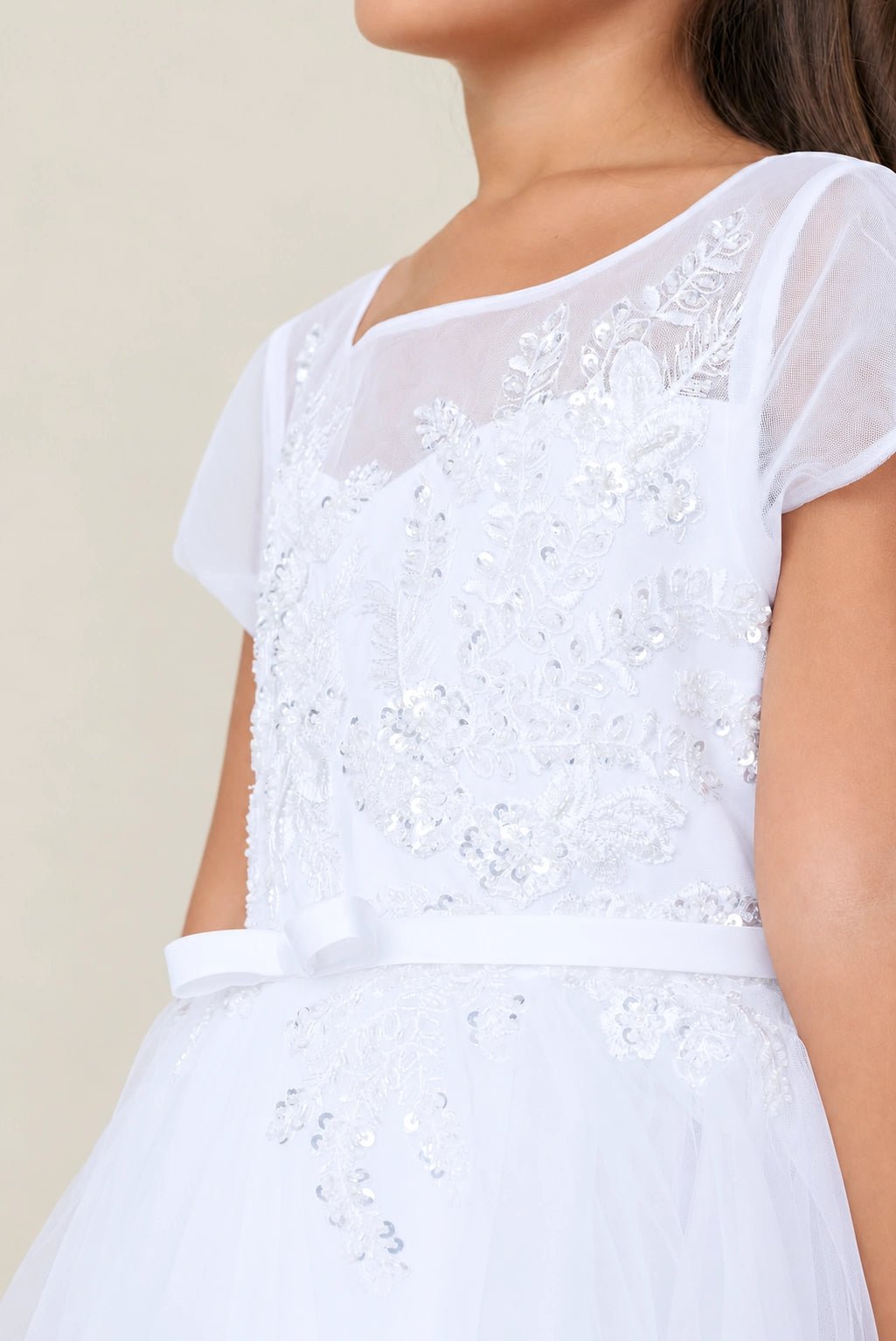 Detailed with short sheer cap sleeves, this white flower girl dress.