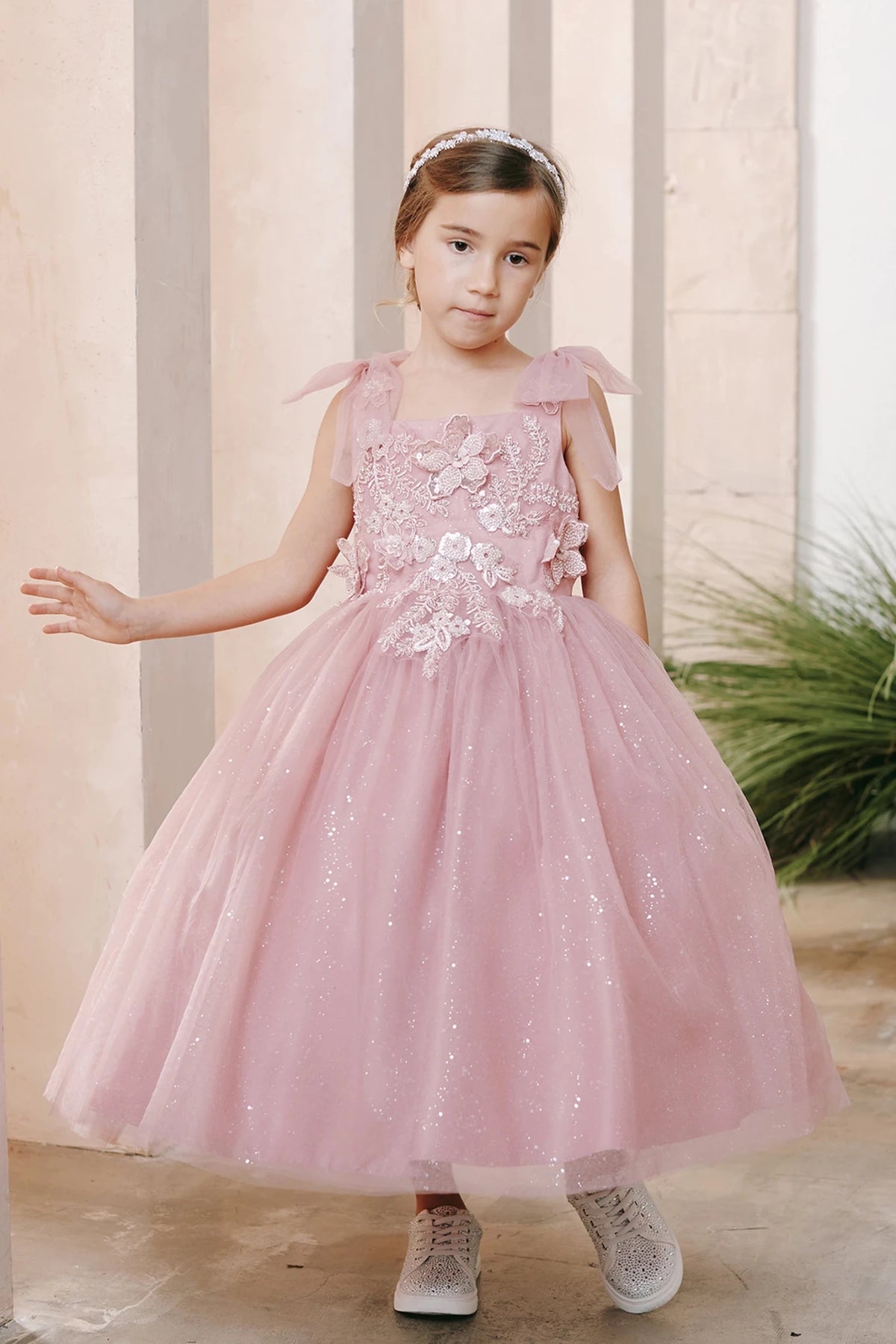 Shown here, a dusty rose flower girl dress with a layered tulle skirt.