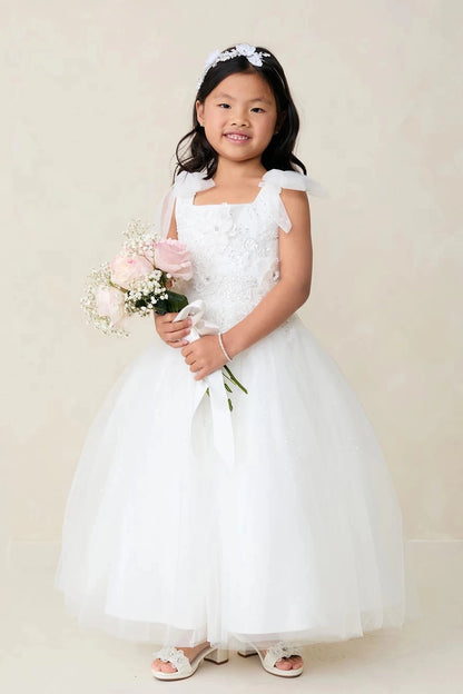 The off-white flower girl dress features shoulder ribbon bows.