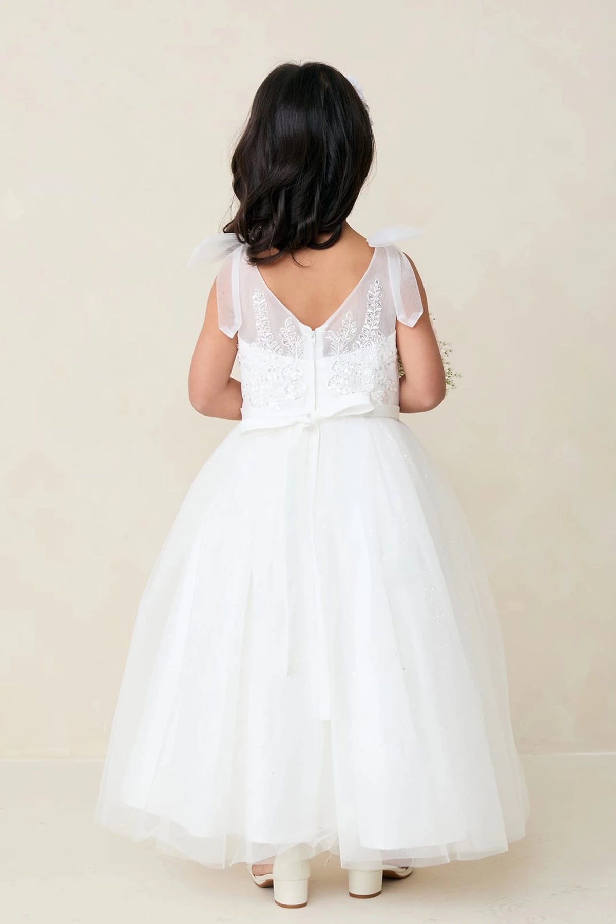 This off-white flower girl dress displays V-shaped lace back.