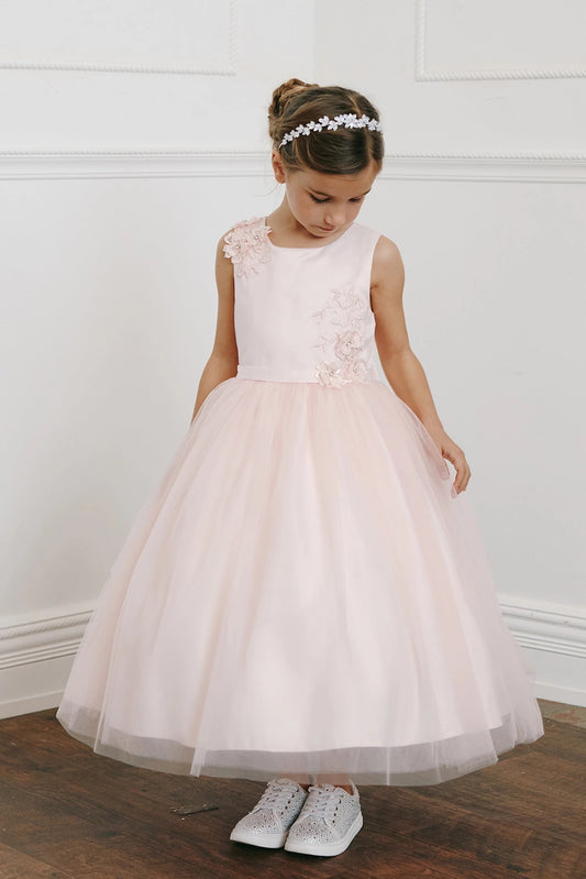 In view: an asymmetric floral bodice of a blush flower girl dress.