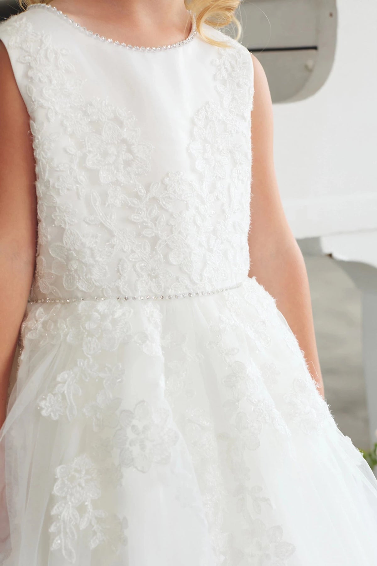 A view of a 3D textured bodice on the off-white flower girl dress.