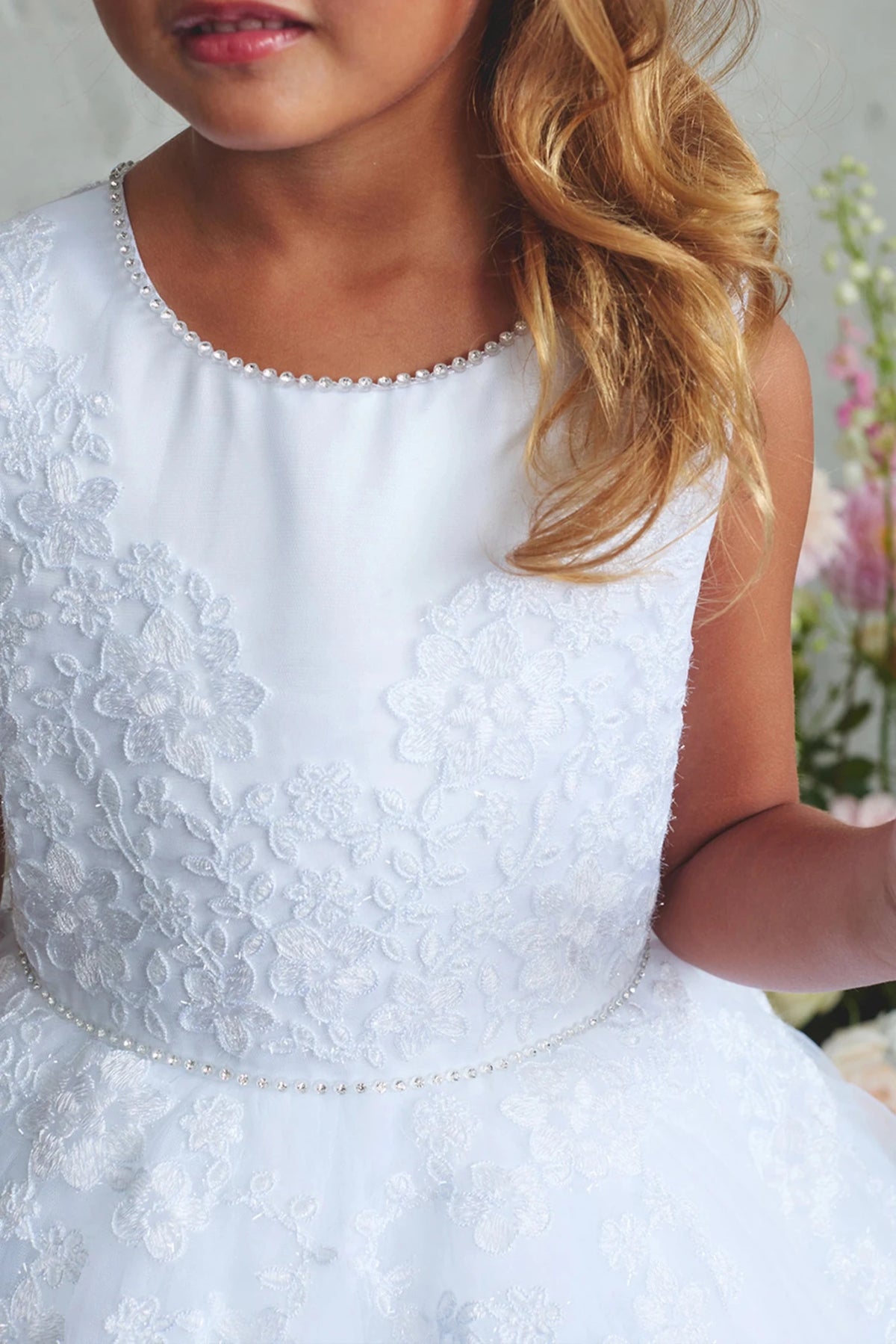 Featuring fine embroidered flowers, a white flower girl dress.