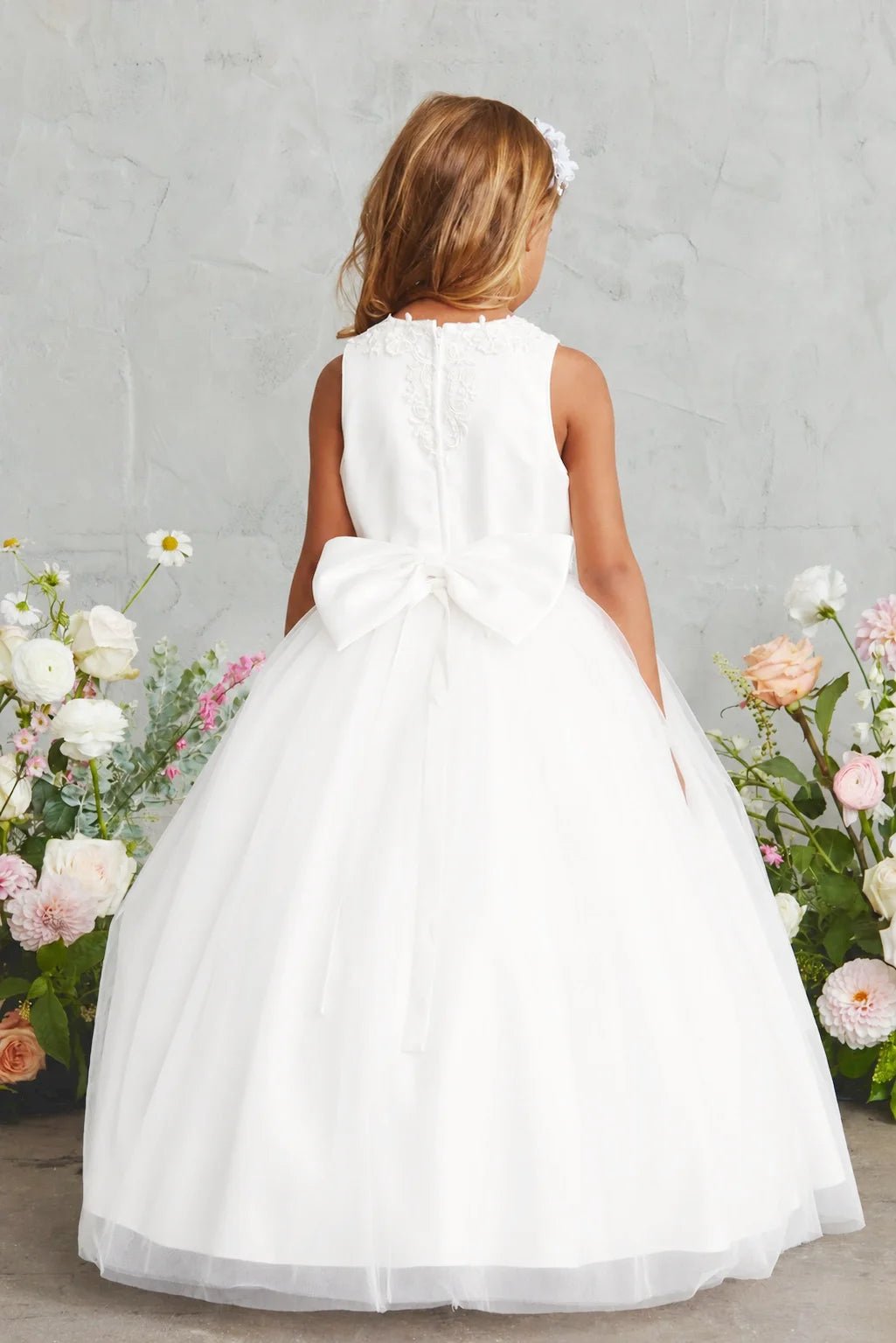 Full back tulle skirt: detail of the off-white flower girl dress.