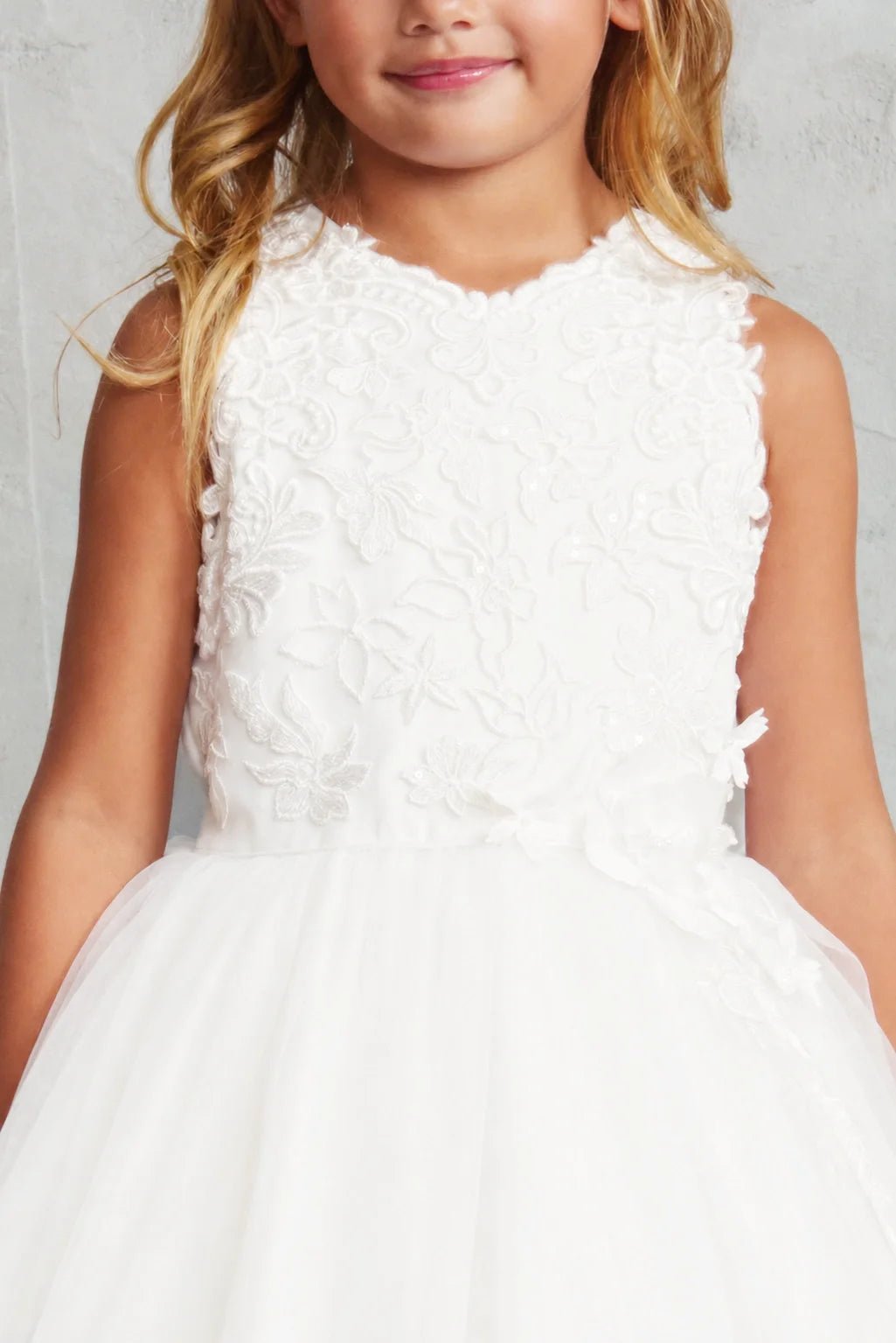 Raised floral embroidery accents this off-white flower girl dress.