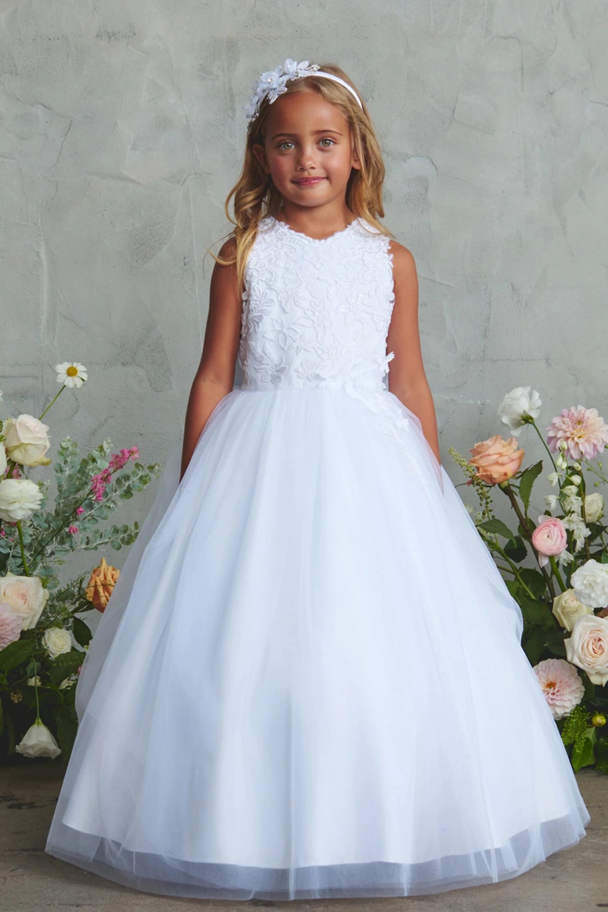 Shown here, a white flower girl dress with a flower-textured bodice.