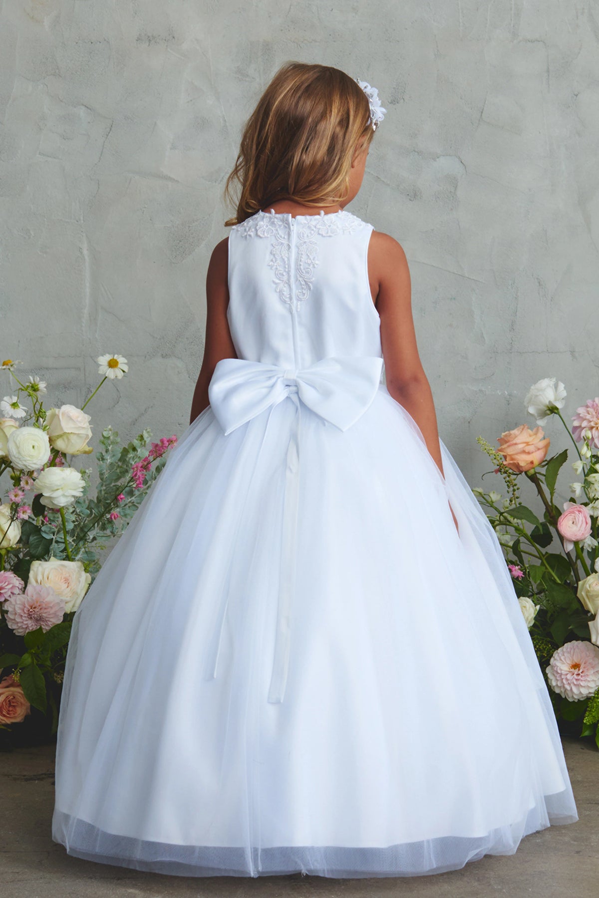 White flower girl dress, showing a large back bow.