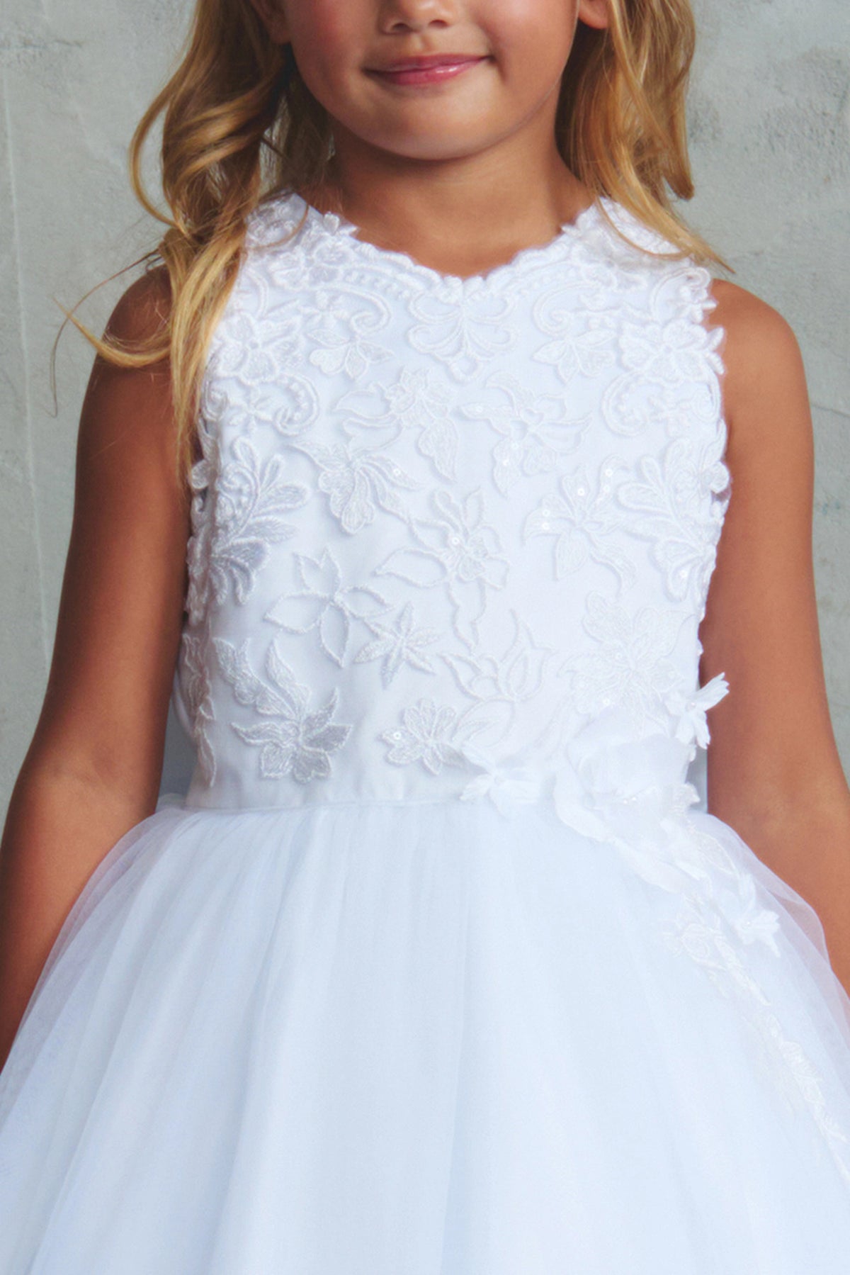 Detailed with a raised floral bodice, this white flower girl dress.