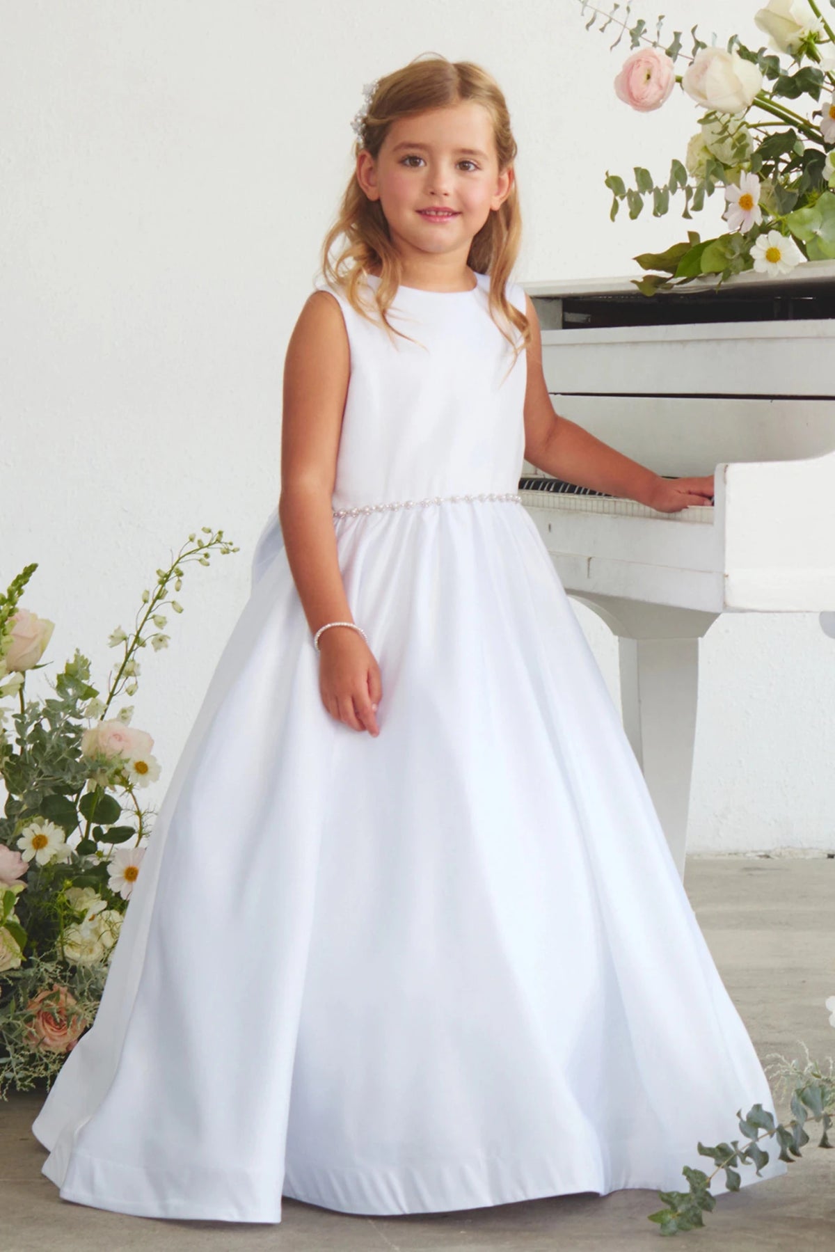 Defined by a beaded waist band, this white flower girl dress.