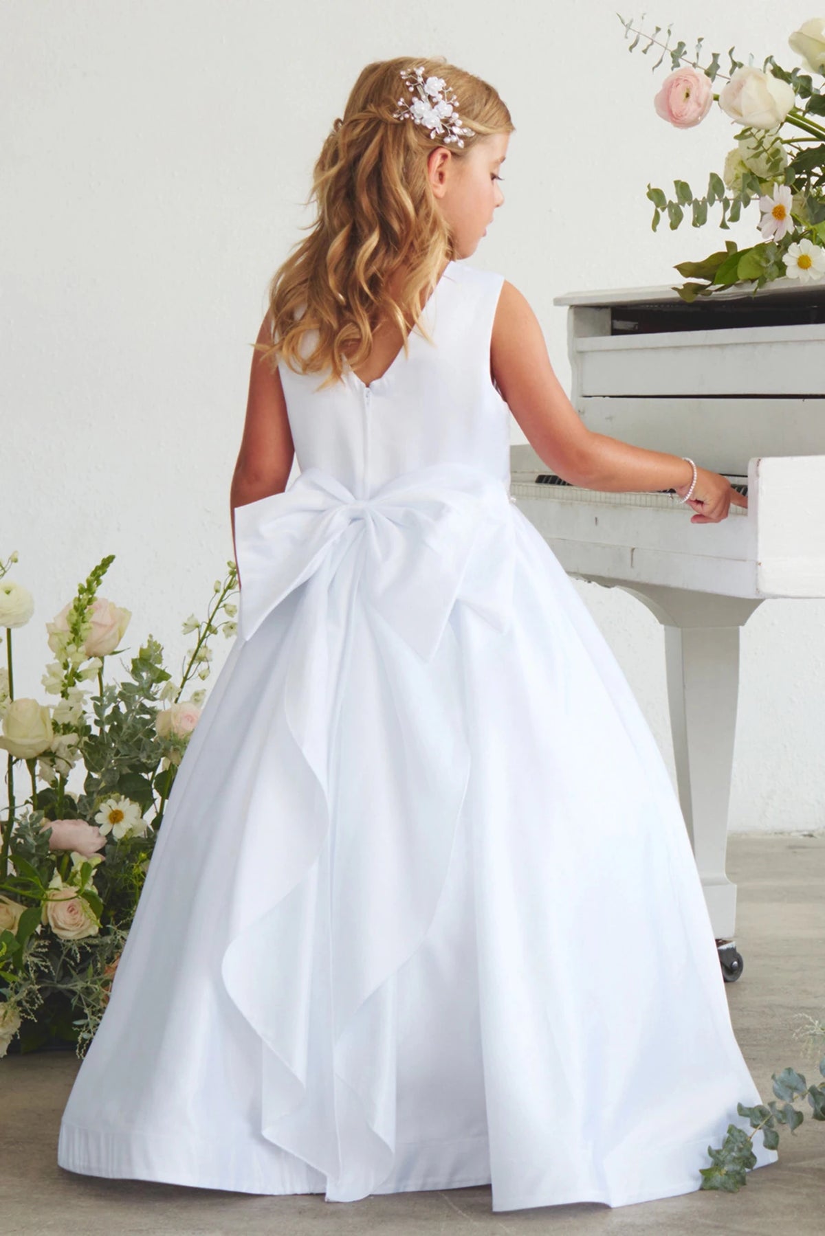 White flower girl dress with a large rear bow.