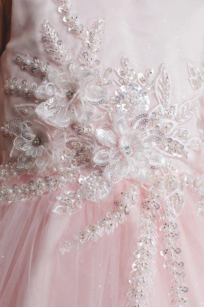 A view of 3D beaded flowers on the blush flower girl dress.