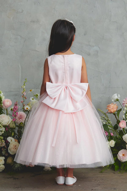 Oversized satin back bow on a blush flower girl dress.