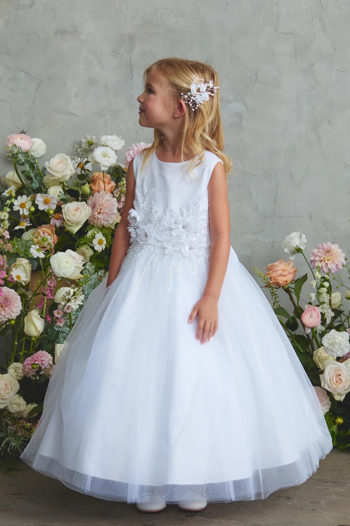 Highlighting a full tulle skirt on a white flower girl dress.