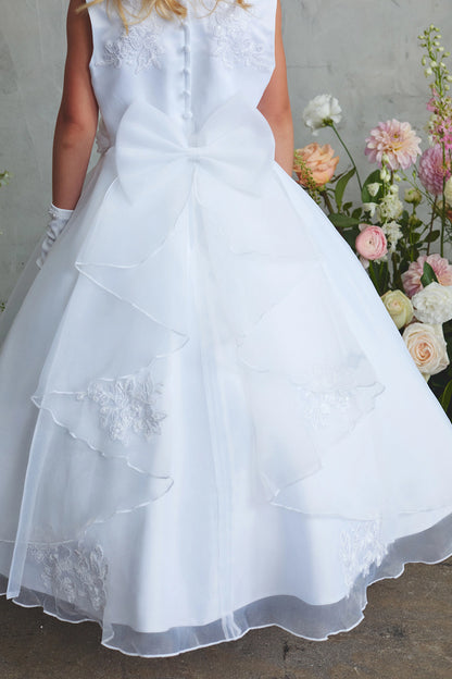White flower girl dress detailed with a large satin back bow.
