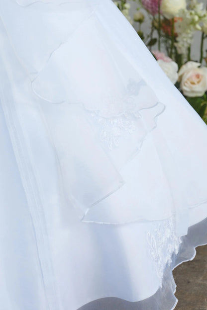 Emphasis on scalloped organza layer of the white flower girl dress.
